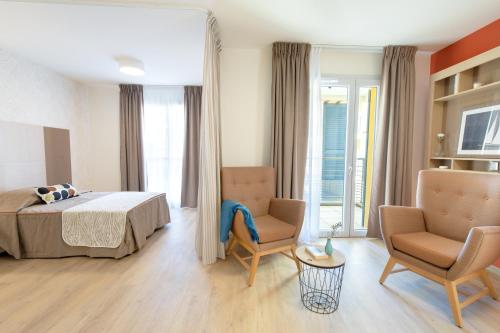 una camera d'albergo con un letto e due sedie di Fréjus Appart'S a Fréjus