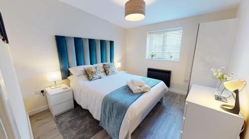 a bedroom with a large bed with blue curtains at Texel Barn in Witney