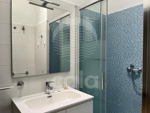 een badkamer met een wastafel en een glazen douche bij Villa Capitano - piscina privata By Cala Salento in Torre Lapillo