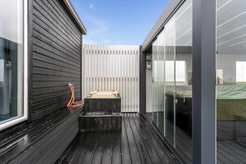 a balcony with a bench on a wooden deck at Selfoss Modern Cabins in Selfoss