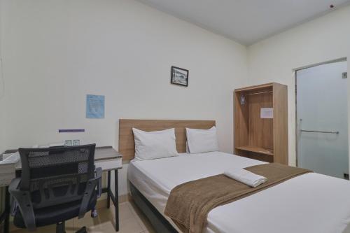 um quarto com uma cama, uma secretária e um computador em Aranis Hotel em Jakarta