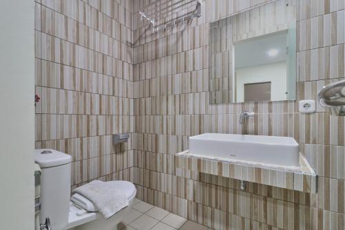 een badkamer met een wastafel en een spiegel bij Aranis Hotel in Jakarta