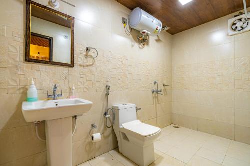 a bathroom with a sink and a toilet and a mirror at The Social Stays Mussoorie formerly ArtBuzz in Mussoorie