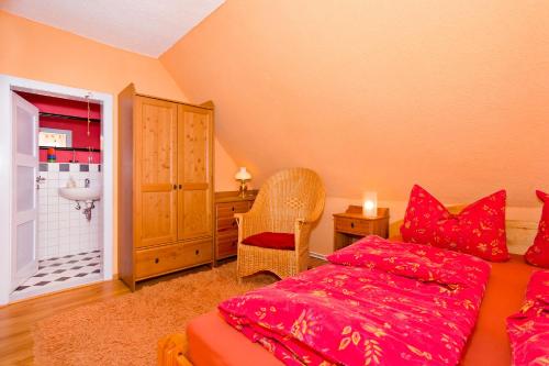 1 Schlafzimmer mit einem roten Bett und einem Badezimmer in der Unterkunft Ferienhaus Namatiri in Putbus