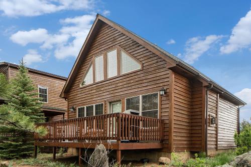 eine Blockhütte mit einer Terrasse und einem Haus in der Unterkunft Solitude Raven #5 - Estes Park condo in Estes Park