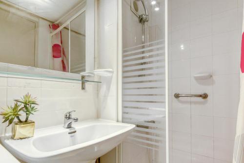 een witte badkamer met een wastafel en een douche bij Karina Mar in Empuriabrava