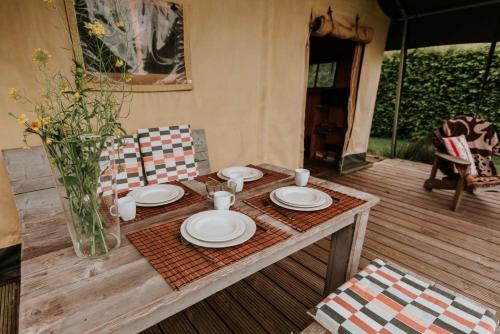 a table with plates and cups and a vase at Kampari in Delfstrahuizen