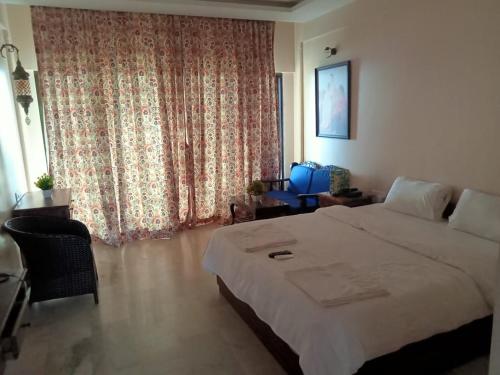 a bedroom with a large bed and a large window at Shiv Sagar Palace,Ganpatipule in Ganpatipule