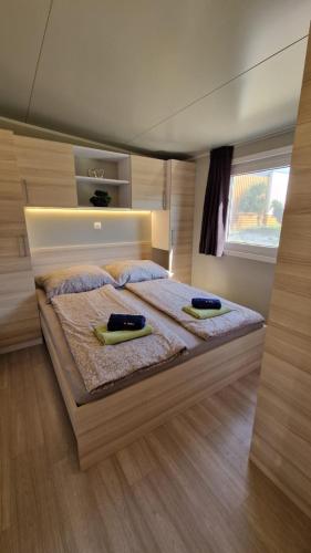 a bedroom with a large bed with two towels on it at Mobile Home Drage in Drage