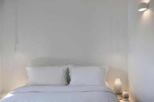 a white bed with white sheets and pillows at Old Castle Oia in Oia