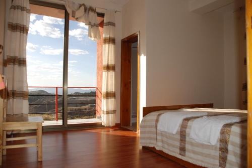 a bedroom with a bed and a large window at Zan-Seyoum Hotel - Lalibela in Lalibela