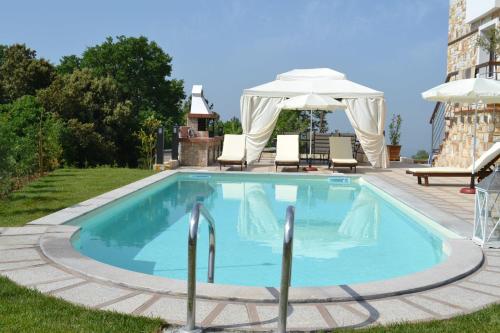 a swimming pool with a gazebo and an umbrella at Evmorfes Villas in Poligiros