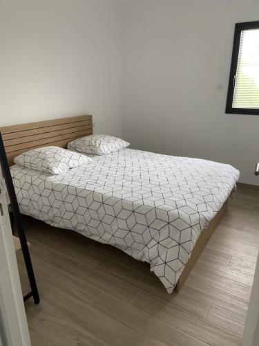 une chambre avec un lit avec une couette blanche dans l'établissement Appartement avec terrasse vue mer, parking privé (lgt B), à Ploemeur