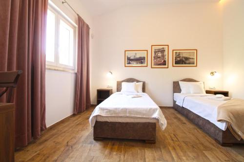 a hotel room with two beds and a window at Villa Olgica 2269 in Pula