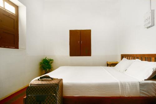 マイソールにあるLaika Heritage Stayのベッドルーム1室(ベッド1台、椅子付)