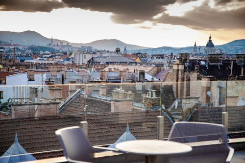 a view of a city from a table and chairs at The Amberlyn Suite Hotel in Budapest