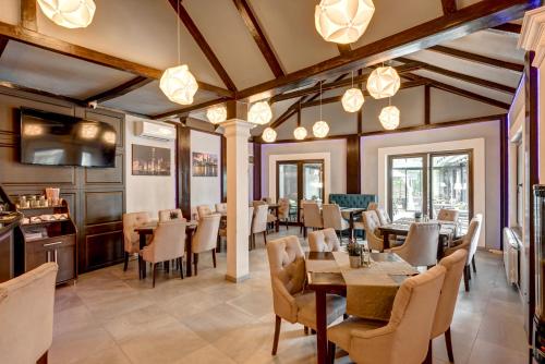 a restaurant with wooden ceilings and tables and chairs at Hotel Roberto Slanic Prahova in Slănic