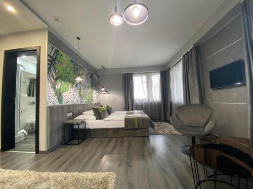a bedroom with a bed and a chair and a mirror at Hotel Central in Kecskemét