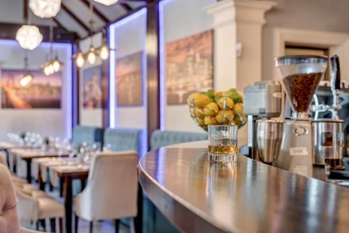 a bar with a counter with a vase of fruit on it at Hotel Roberto Slanic Prahova in Slănic
