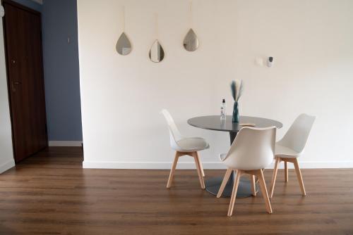 a dining room with a table and white chairs at Naiads Nest - The Comfort Lux in Varkiza