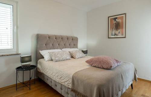 a bed with two pillows on it in a bedroom at Pool apartment Ena in Pag