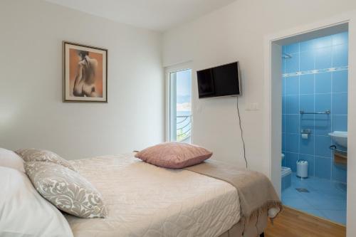 a bedroom with a bed and a bathroom with a window at Pool apartment Ena in Pag