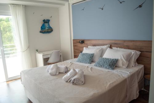a bedroom with a large white bed with towels on it at Naiads Nest - The Comfort Lux in Varkiza