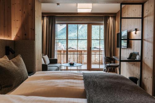 Una habitación de hotel con una cama y una ventana grande. en NOVA Moments Boutique Hotel, en Pertisau