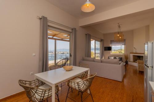 a kitchen and living room with a white table and chairs at Phaos in Kyparissia