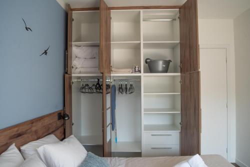 a bedroom with a closet with shelves and a bed at Naiads Nest - The Comfort Lux in Varkiza