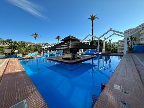 a swimming pool with a fountain in the middle at Luxury frontal al mar Benalbeach in Benalmádena