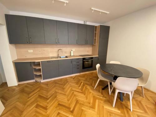 a kitchen with a table and chairs in a room at Apartments TITO & ROBIN in Koper