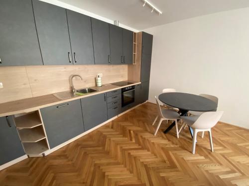 a kitchen with gray cabinets and a table and chairs at Apartments TITO & ROBIN in Koper