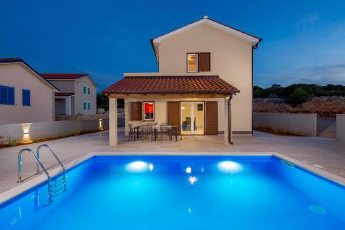 a villa with a swimming pool in front of a house at Villa Giulietta in Vrbnik