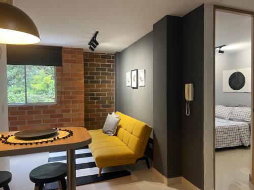 een woonkamer met een gele stoel en een tafel bij Apartamento Moderno Estelar in Sabaneta