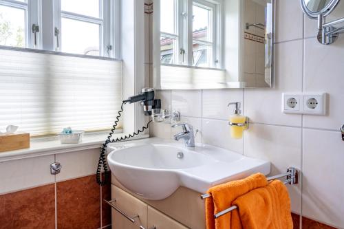 a bathroom with a sink and a mirror at Inselhotel Arfsten in Wyk auf Föhr