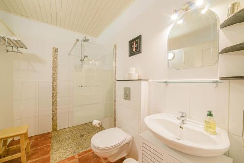 a white bathroom with a toilet and a sink at Lot & Garonne - Magnifique gîte de groupe avec piscine et vue panoramique en pleine campagne Proche Agen in Castelmoron-sur-Lot