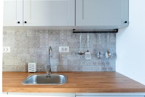 a kitchen with a sink and white cabinets at Apartment Trg in Brežice