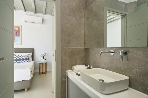 a bathroom with a sink and a mirror at Villa j-view in Psarou