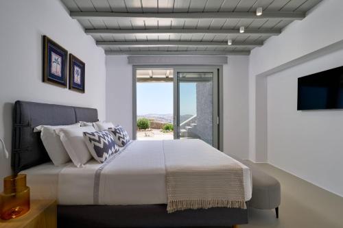 a bedroom with a large bed and a window at Villa j-view in Psarou