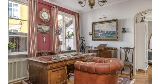 an office with a desk and a chair and a clock at Stor och lyxig villa mitt i Visby innerstad in Visby