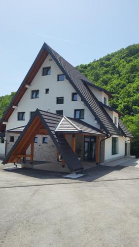 een groot wit gebouw met een gambrel dak bij Janjska Kuća in Šipovo