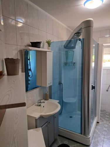 uma casa de banho com uma cabina de duche em vidro e um lavatório. em Holiday Hana em Kastav