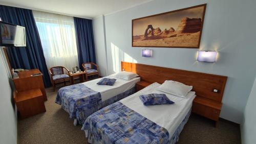 a hotel room with two beds and a table at Aqua Hotel in Varna City