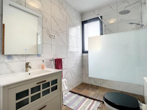 a bathroom with a white sink and a toilet at Casa Teixeira by Atlantic Holiday in Estreito da Calheta