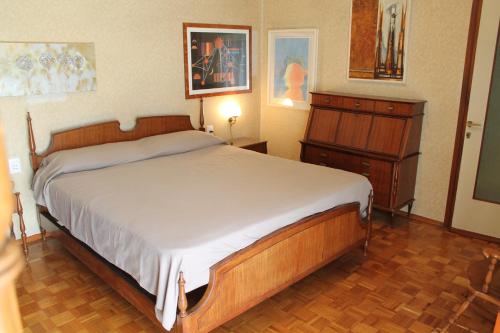 a bedroom with a large bed and a dresser at L'appartamento della Stazione di Saronno in Saronno