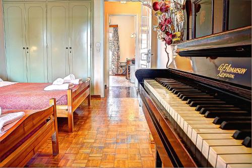 a living room with a piano and a bedroom at Hotel Benitses Arches in Benitses