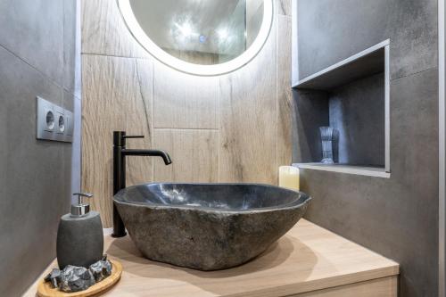 a bathroom with a large stone sink and a mirror at MalagaSuite Huelin Urban Estudio in Málaga