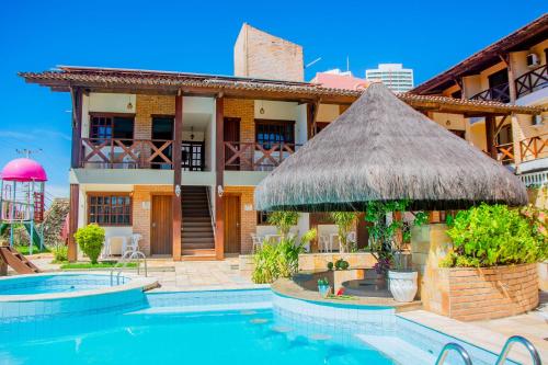 een villa met een zwembad en een gebouw bij O Tempo e o Vento in Natal