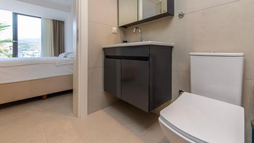 a bathroom with a toilet and a sink and a bed at Villa House Sea View Türkbükü in Bodrum City